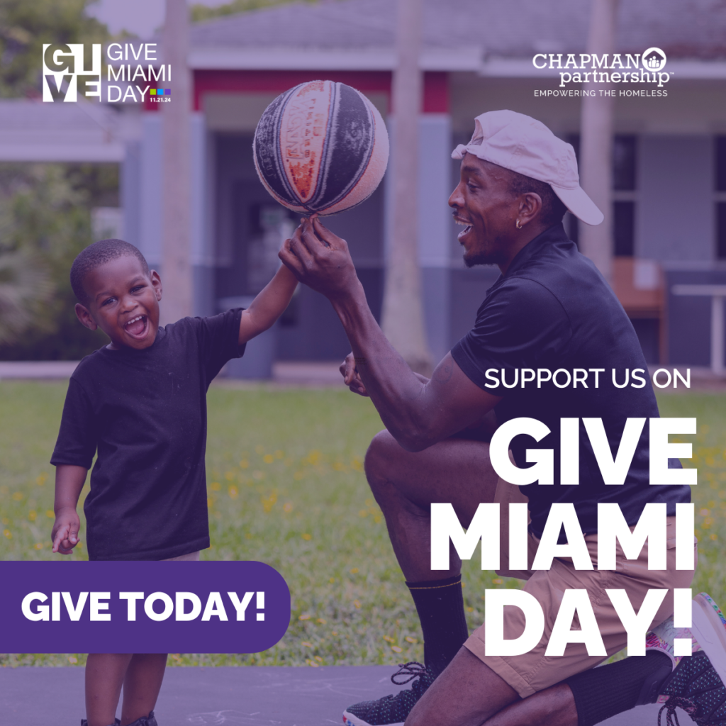 A father and son sharing a proud moment on the basketball court, overlaid with a purple tint. The words "Support Us on Give Miami Day!" are displayed on the bottom right corner in white letters, with a purple button that says "Give Today!" also in white letters. Button leads to the Give Miami Day. fundraising page. Images include the Give Miami Day logo and the Chapman Partnership logo. 